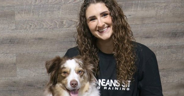 a woman with her arm around a dog posing for a photo