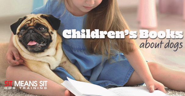 Child sitting on the floor with a pug, looking at a book about dog training.